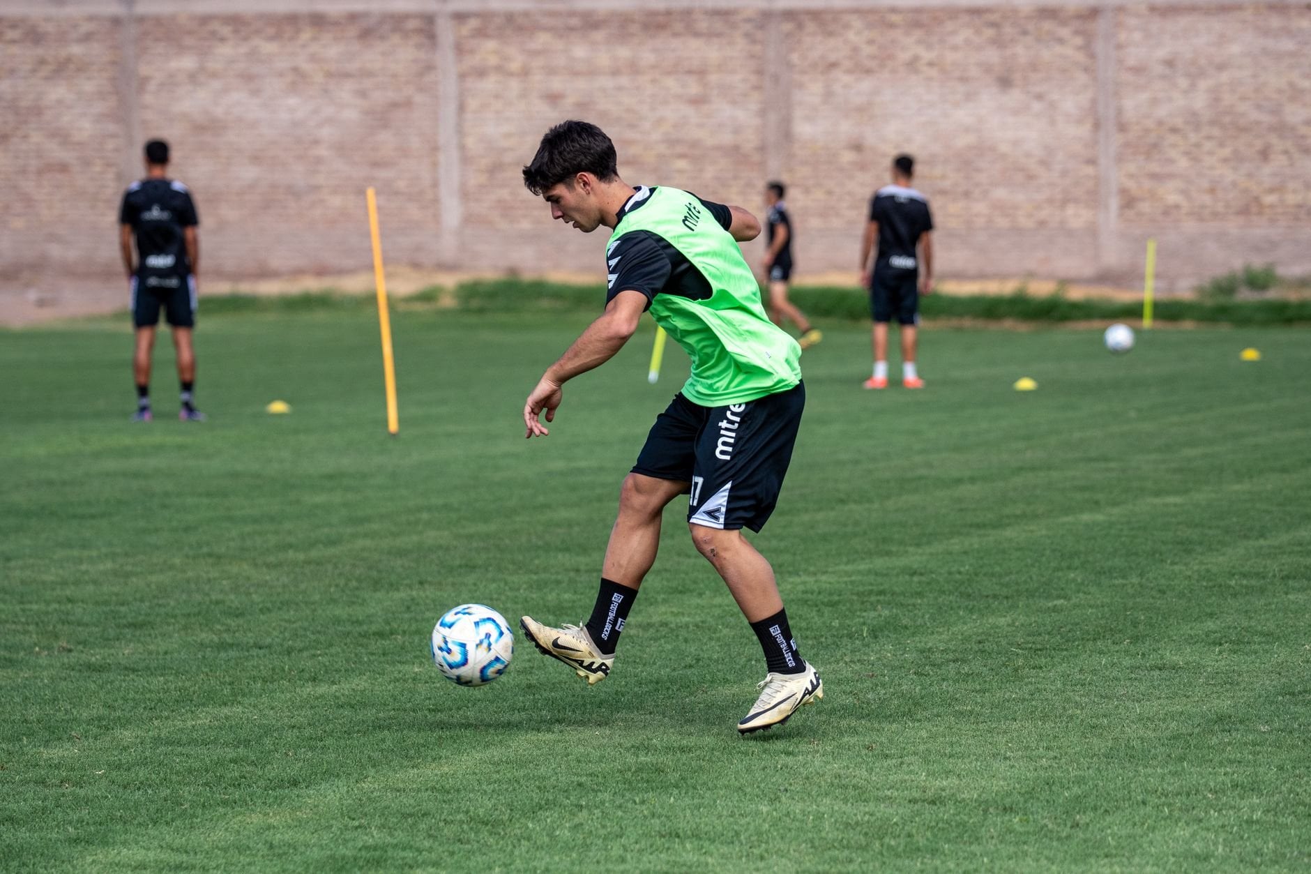 Young footballer dribbling during training drill